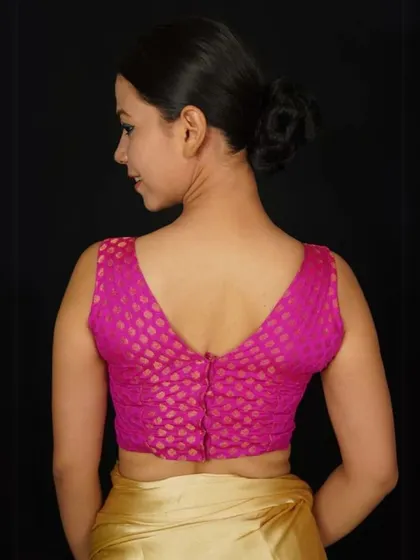 This pink brocade blouse features a deep V-back, adding a touch of allure to its traditional design.