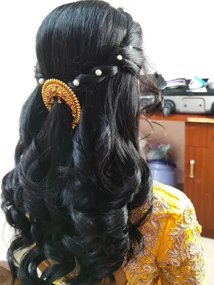 Another angle of the half-up style, showing the placement of the traditional gold accessory and pearl details.