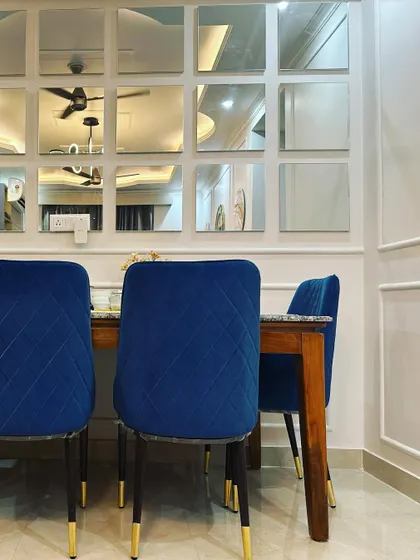 The mirrored wall in this dining room reflects the ceiling and fan, adding to the illusion of height and space.