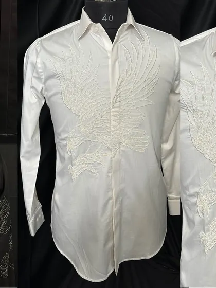 A collage featuring the white eagle shirt. The detailed, tone-on-tone embroidery creates a subtle yet powerful statement, showcasing the texture and artistry of the craft.