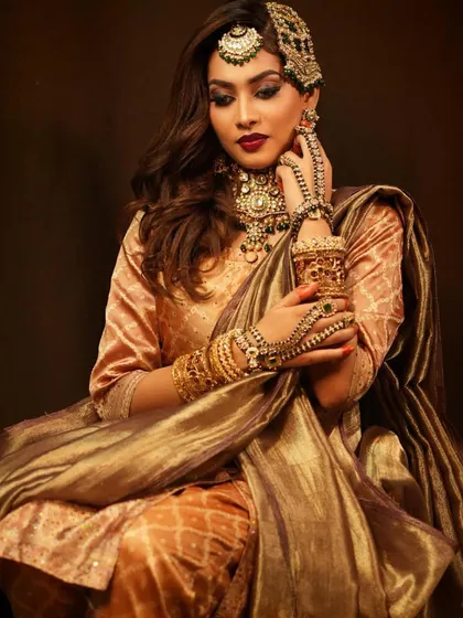 This seated pose highlights the flow and fabric of the elegant saree. Our students learn posing and photography basics to best showcase their work in a portfolio.
