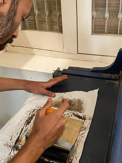Applying ink to a plate with a roller. The tools and techniques of printmaking have a long history, and connecting with these traditions enriches my contemporary design practice.