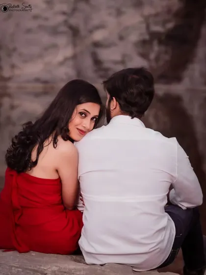 An intimate pre-wedding shot from behind the groom. The bride's loving gaze over his shoulder creates a sense of privacy and romance, as if we're getting a glimpse into their personal world.