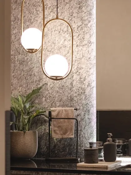 A close-up of the powder room's lighting, where modern brass fixtures contrast beautifully with the textured wallpaper.