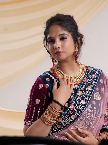 A close-up of the navy blue velvet lehenga, showing the detailed embroidery on the blouse and the beautiful traditional jewelry set that comes with it.