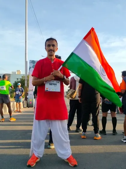 A participant in a traditional kurta stands with the Indian flag, embodying the cultural and patriotic spirit of our Independence Day run.