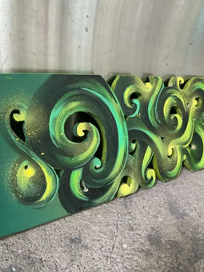 A side angle of the carved skateboard, showing the texture and dimension of the Hindi lettering.