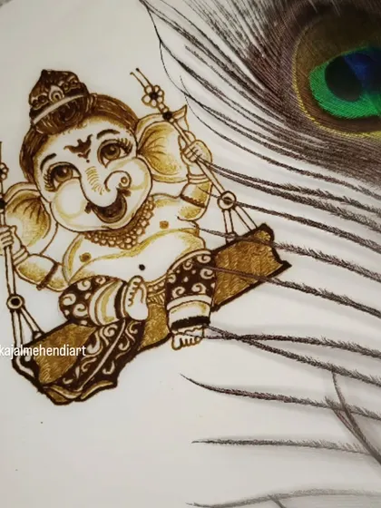 A beautifully styled shot of my Ganesha portrait, created with henna on paper and placed next to a peacock feather. This design is a favorite for festive occasions.