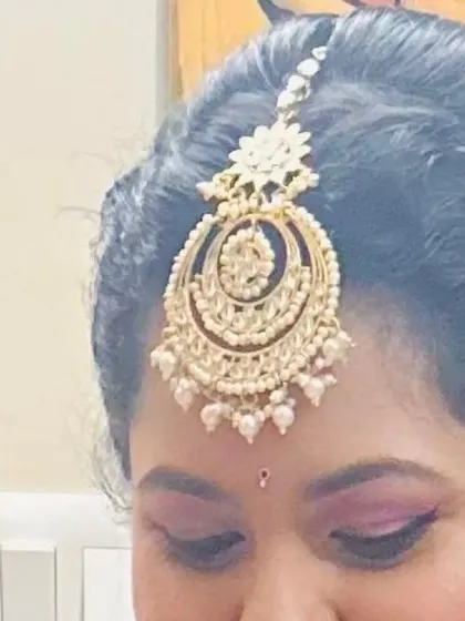 A close-up of the beautiful maang tikka and eye makeup for a party look. The pink eyeshadow is blended perfectly for a soft, glamorous effect.