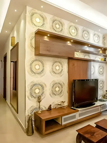To make this TV unit stand out, we used a bold, circular-patterned wallpaper as the backdrop. The wooden shelves and console complement the design, creating a vibrant and personalized entertainment space.
