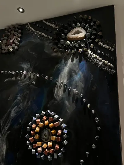 A close-up of the natural stone arrangements on the astrology-themed wall art. Each cluster represents a planet, with a geode at its center.