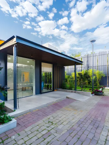 The entrance to the Prestige modular office, featuring a covered porch and accessible ramp. The design is both welcoming and practical, with large glass doors that fill the interior with natural light.