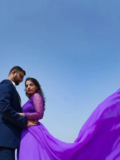 A dramatic shot of the lavender tail gown against the sky. This gown is designed for creating epic, memorable photos for your pre-wedding album.