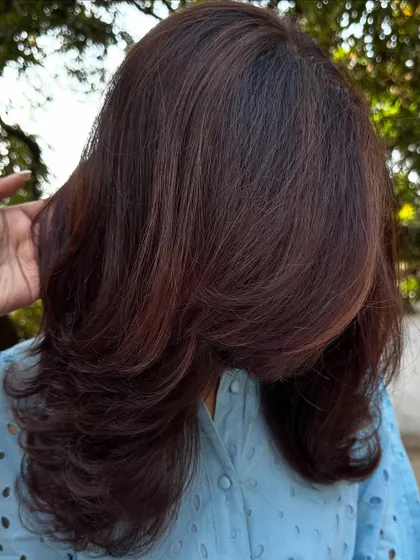 A portrait of the client with her new 'Mahogany + Plum' hair.