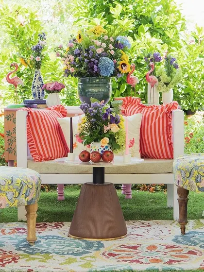 A cozy seating nook at the Srinagar welcome lunch, with a mix of floral and striped prints, vibrant colors, and a beautiful patterned rug.