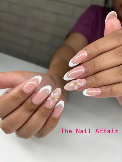We've updated the classic French manicure with delicate, hand-painted daisy art on the accent nails. This almond-shaped set shows how we add a personal, artistic touch to a timeless style.