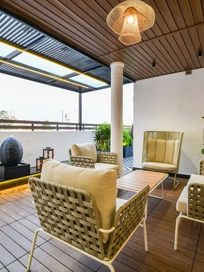 This balcony is all about creating a refreshing outdoor experience, with its open layout, natural wood tones, and a modern water feature that adds a sense of tranquility.