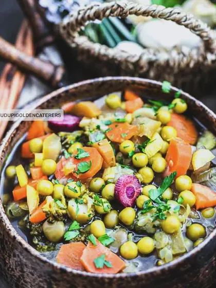 This is our Mixed Vegetable Soup, a hearty and nutritious option packed with peas, carrots, and other seasonal vegetables in a clear broth.