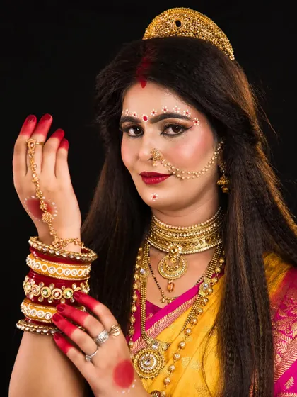 A beautiful depiction of Skandamata, the mother goddess. The makeup is soft yet divine, and the crimped hair adds texture and volume to the overall look.