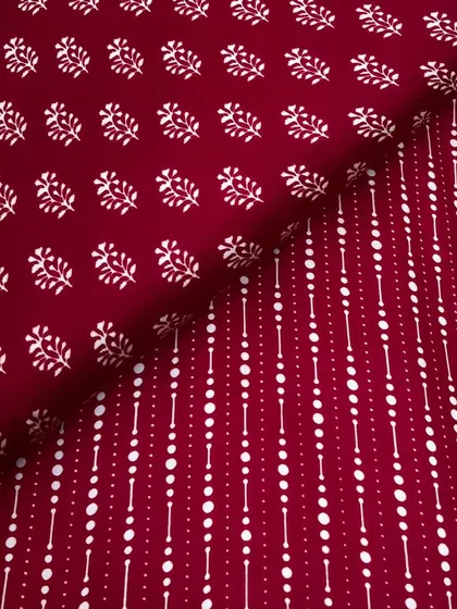 This printed modal satin features a combination of a traditional buti print and a modern geometric design in a rich maroon color.