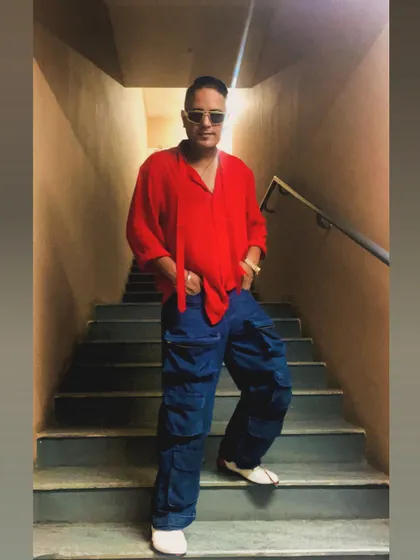 A stylish look for a weekend gig announcement. The red shirt and baggy jeans combo is all about that relaxed 90s hip-hop vibe.
