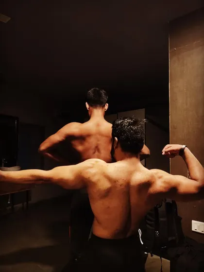 A back-to-back posing shot, showing the different structures of our back muscles.