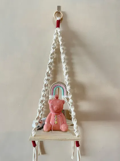 A simple and elegant macrame shelf. The spiral knots and minimal design make it a versatile piece that can hold a small plant, a candle, or other treasures.