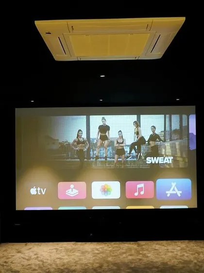 The Apple TV interface on the big screen, ready for a fitness session. This shows how a home cinema can be a versatile space for entertainment, gaming, and even workouts.
