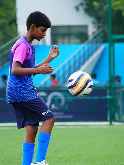 A player practices his first touch, controlling the ball with his knee.