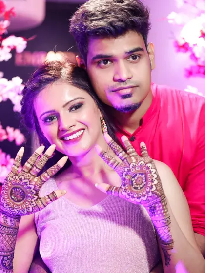 A happy couple posing with the bride's beautiful mandala mehndi. It's a design that looks great from every angle.