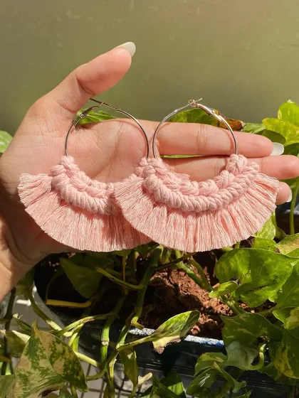 Our boho fringe macrame earrings are lightweight and make a beautiful statement. These hoop earrings feature soft, baby pink knotted details and a fringed edge for a touch of bohemian style.