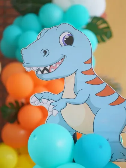 A friendly T-Rex cutout, part of the dinosaur theme props.