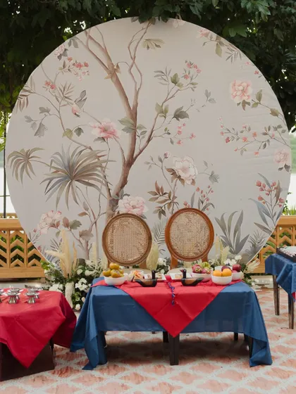 The complete setup for the Paebaek ceremony, featuring the traditional red and blue table cloths, symbolic food offerings, and a beautiful circular backdrop with a hand-painted tree.