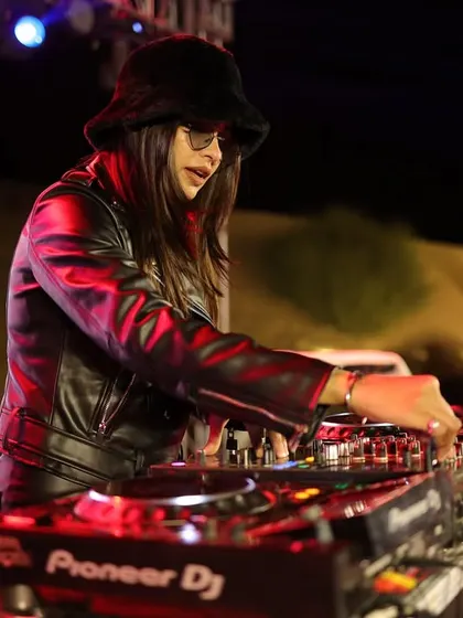 A candid shot of me DJing in a bucket hat and leather jacket at the Jaisalmer NYE party. This shows my versatile style, adapting to the vibe of the event.