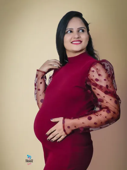 A simple, modern studio portrait. This mom-to-be chose a stylish dress that beautifully highlights her baby bump against a neutral background.