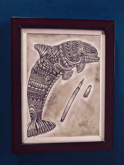 A zentangle dolphin drawing, with a pen included in the frame to show the tool of creation.