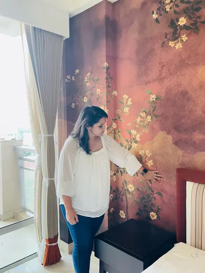 Here I am on-site, reviewing the final installation of the autumn-themed bedroom wallpaper, ensuring every detail and color is perfect.