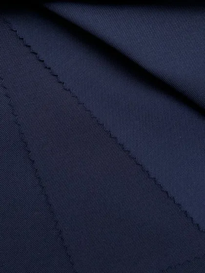 A close-up of a dark navy wool fabric, showing its fine weave and luxurious finish.