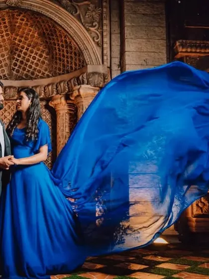 The trail of the blue gown is tossed for a motion effect, beautifully catching the light in this architectural setting.