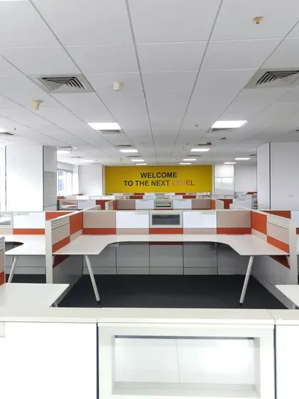 A wide view of the open-plan office floor, showcasing the scale of our design capabilities. The layout uses repeating workstation modules and color-coded partitions to create a sense of order and rhythm across a large footprint.