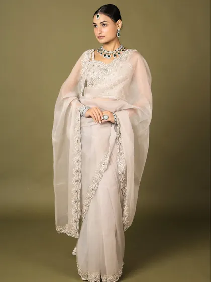 A full-length view of a model wearing our diamond necklace collection. This image showcases how our pieces can elevate a simple, elegant saree.