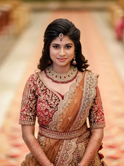 A classic portrait of the bride. The makeup is perfectly balanced with her heavy jewelry and embroidered lehenga.