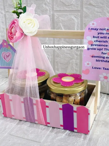 This image showcases the full pink-themed return gift basket, with its personalized card and beautifully arranged contents.