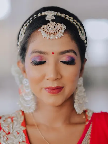 A serene portrait with eyes closed, allowing a full view of the beautiful purple and pink eyeshadow. This is a great shot for a makeup artist's portfolio and for brides looking for inspiration.