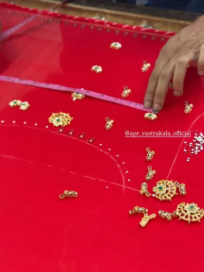 A glimpse into the creation process of a jewellery concept blouse. You can see the individual kemp and stone pieces being meticulously placed and hand-stitched onto the fabric.