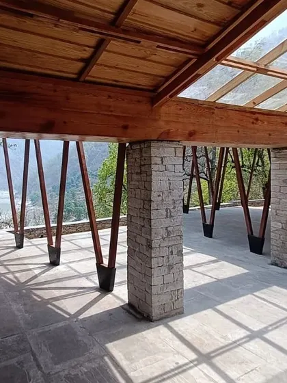 **Angling Centre, Pancheshwar:** A detail of the stone pillar and angled wooden supports. This highlights the joinery and the honest expression of materials, a core part of our design philosophy, especially when working in natural contexts.