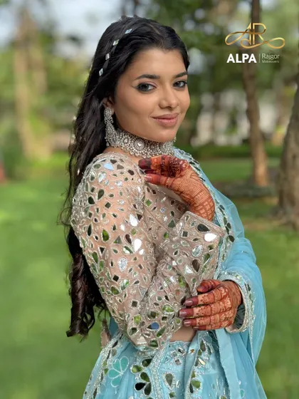 A portrait of the Sangeet look, showing the glowing skin, silver jewelry, and a hairstyle that is both intricate and elegant.