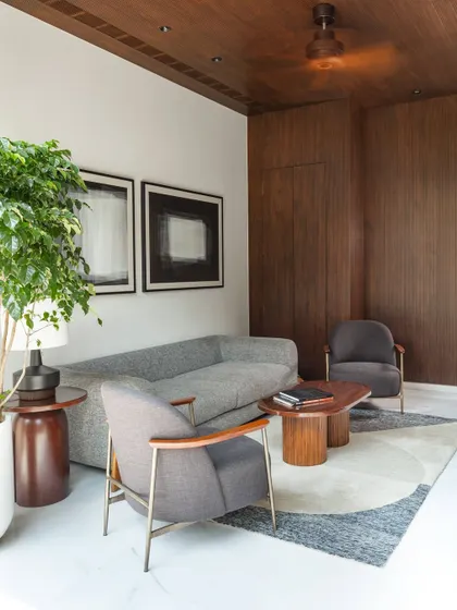 A cozy family lounge area featuring a warm wood-paneled ceiling and comfortable, modern furniture. This space is designed as a social hub for daily interactions and relaxed gatherings.