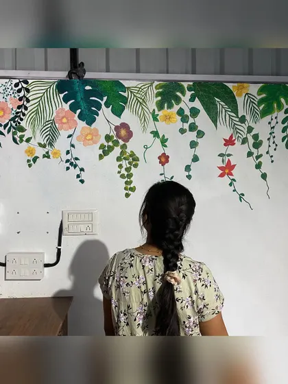 We love painting different styles of tropical murals. This one features hanging monstera leaves and floral creepers, creating a delicate and airy feel on the wall of a restaurant.