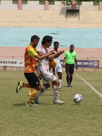 A player skillfully maneuvering the ball on the sideline during our fourth game.